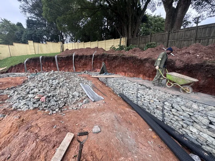 Gabion cages filled with stone along the excavated Hillcrest embankment.