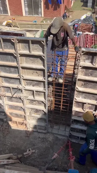 Wall formwork and crew during reinforced concrete construction.