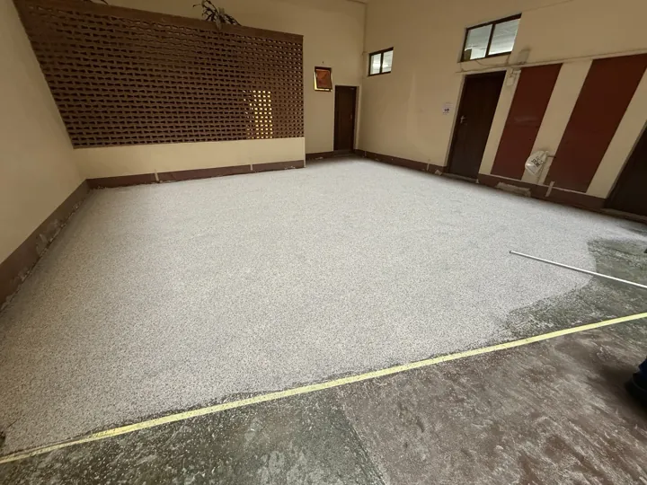 Partially coated speckled floor with application materials in the Amanzimtoti interior.