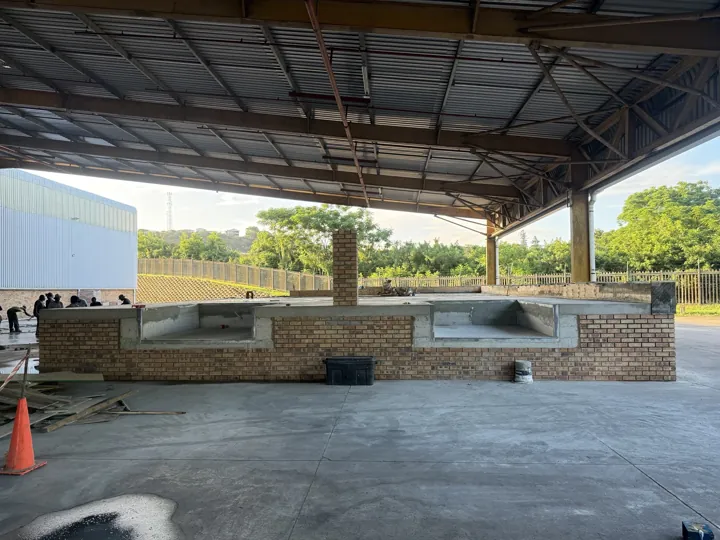 Wide view of the completed face-brick and concrete dock leveller platform under the industrial roof.