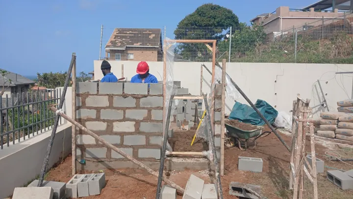 Storage building block walls and door opening under construction before plastering and roofing.
