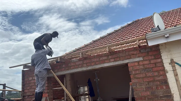 Crew working at a roof extension above new brickwork.