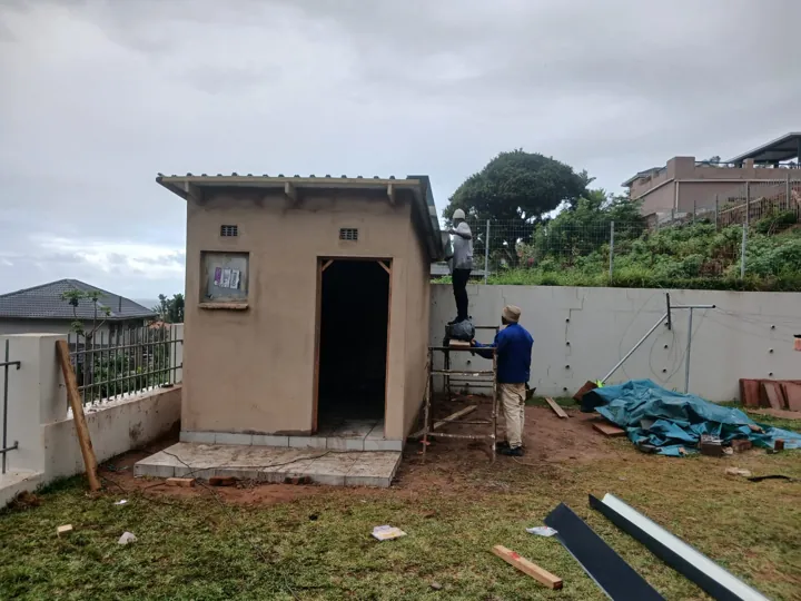 Storage building with plastered walls and IBR roof in place while construction continues.