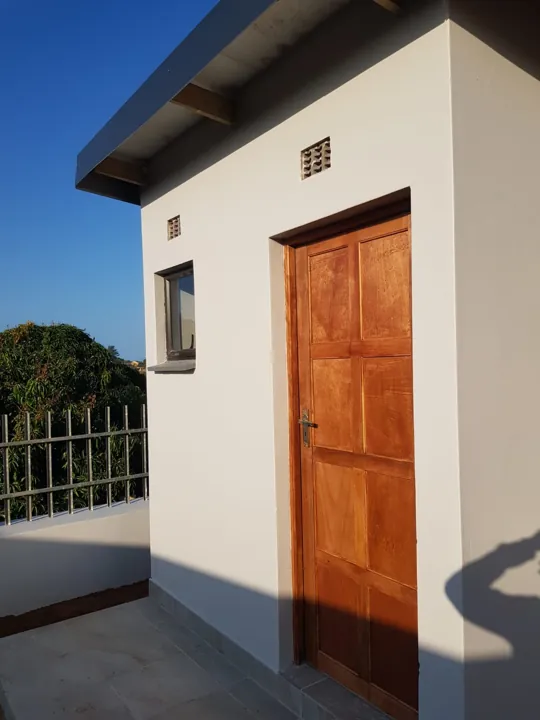 Finished Tongaat storage building entrance with a wooden door, a window and painted exterior beneath the IBR roof.