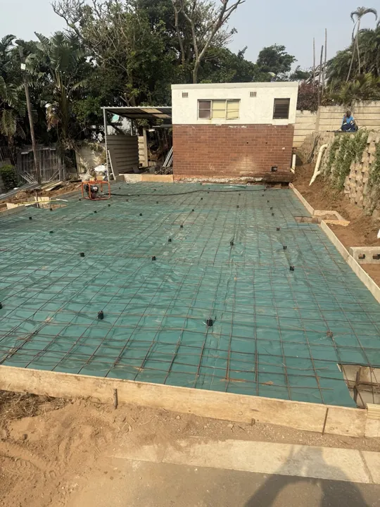 Prepared garage slab area with reinforcing mesh laid before concrete placement.