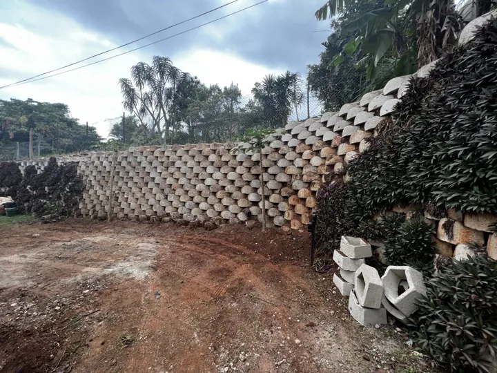 Wide view of a block retaining wall around an exposed site area.