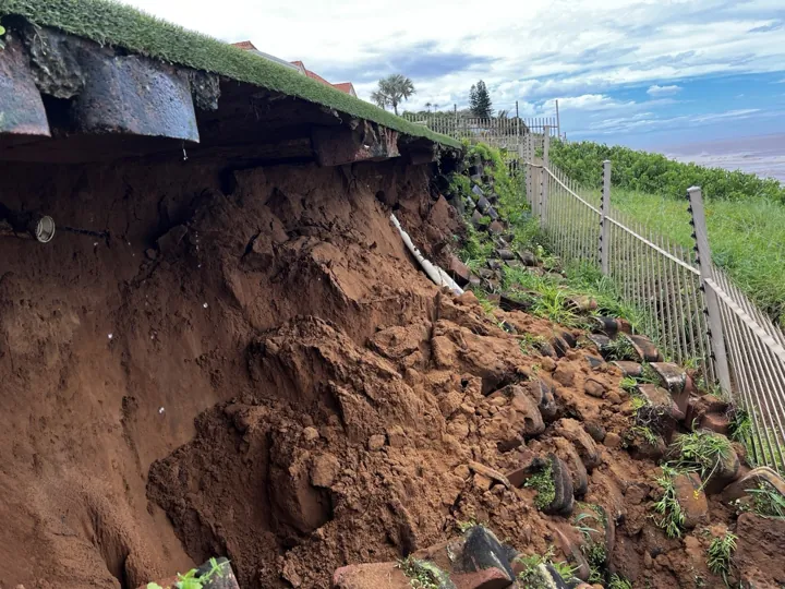 Collapsed slope below a lawn and palisade fence at the Umhlanga site.