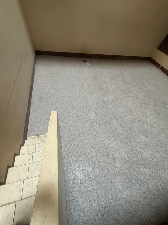 Completed speckled epoxy floor beside the steps and low wall in Amanzimtoti.